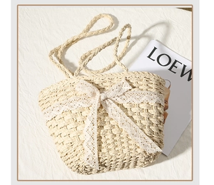 Detailed weave of straw beach bag featuring a delicate white lace bow decoration