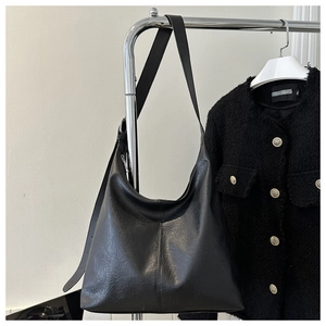 Detail view of black PU leather hobo bag with wide shoulder strap and center stitching