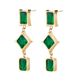 Detail of gold hanging earrings with three emerald green geometric crystals in a drop style