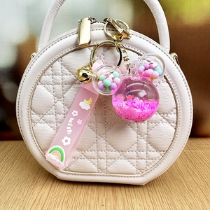Cute cartoon mouse head keychain with pink liquid quicksand and sequins on a white bag