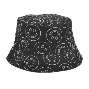 Detailed view of white embroidered smiley faces on a black canvas bucket hat fabric