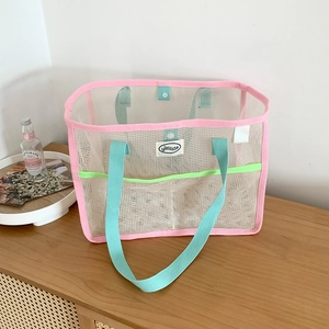 Detailed shot of mesh beach bag showing breathable beige net and pink green accents