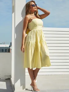 Detail of light yellow tiered summer dress with thin straps and breathable fabric