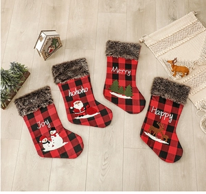 Chaussettes de Noël à carreaux avec revers en fourrure et motifs sur sol en bois
