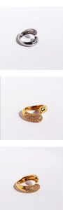 Macro detail of gold and silver C-shaped ear cuffs with cubic zirconia pavé setting