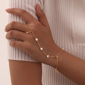 Detail of 18K gold plated slave bracelet featuring three clear crystals on a female model