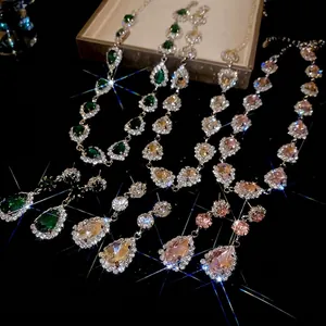 Luxurious pear-cut jewelry set with emerald, champagne, and pink rhinestones on black