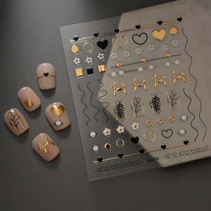 Detailed macro view of 5D gold embossed heart and line art nail stickers on nude nails