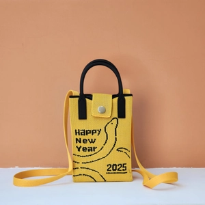 Detail of yellow knit phone bag featuring black Happy New Year 2025 embroidery text
