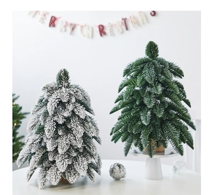 Miniature flocked cedar Christmas trees with natural wood bases on a desktop setting