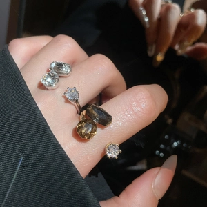 Detailed view of layered silver and gold rings featuring geometric zircon stones