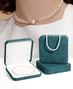Dettaglio della scatola ottagonale in pelle PU verde scuro con collana di perle eleganti