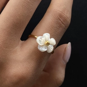 Gold stainless steel ring with white mother-of-pearl flower on a female model