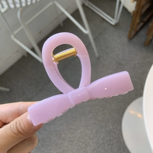 Detail of lavender bow hair claw clip with golden spring mechanism for high ponytail