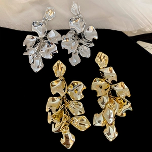 Close-up of gold and silver cascading petal tassel earrings on dark velvet