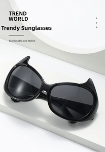 Detail of black devil horn sunglasses with dark lenses on a geometric platform