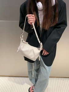 White minimalist leather underarm bag featuring adjustable strap and metallic hardware details
