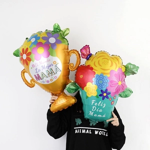 Mother's Day trophy and flower bouquet balloons with Spanish text held by model