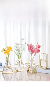 Close-up of geometric gold iron vases with 'Love' script and glass hydroponic tubes