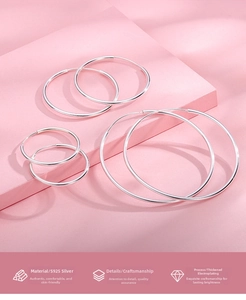 Close-up of three sizes of S925 sterling silver hoop earrings on a pink minimalist background