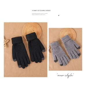 Detail of grey and black winter knit gloves showing touchscreen fingertips and warm texture