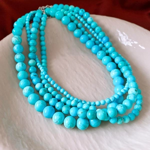 Détail macro d'un collier de perles turquoise multicouches avec matrice naturelle sur plat