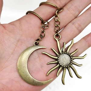 Vintage bronze sun and crescent moon pendant keychain with antique stone inlay detail