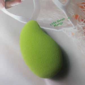 Detailed macro view of mango-shaped makeup sponge with soft porous texture in green
