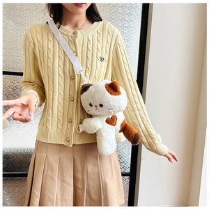 Detail of cute calico cat plush bag with brown heart pattern and white shoulder strap