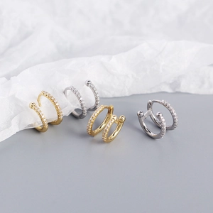 Detailed close-up of double-layer gold and silver hoop earrings with micro-set zircon crystals