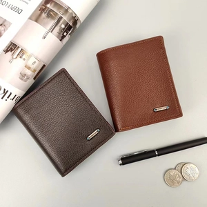 Detalle de carteras de cuero para hombre en marrón oscuro y caramelo con un logotipo de metal