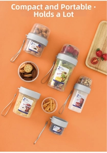 Dual-layer clear plastic food containers with grey lids for salad and snacks on orange background