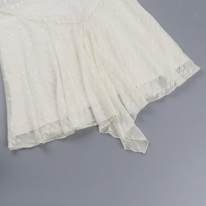 Detailed close-up of white lace floral crochet hemline and semi-sheer fabric texture
