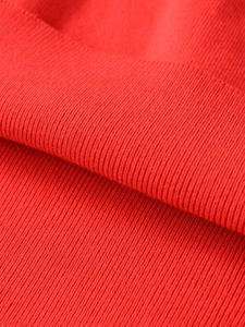 Close-up detail of high-density red ribbed knit fabric texture on long sleeve jacket