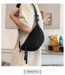 Detailed back view of a black crescent nylon crossbody bag worn on a casual beige t-shirt