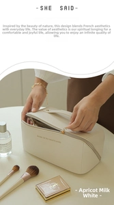 Detail of creamy white leather makeup bag with dual zippers and large capacity interior
