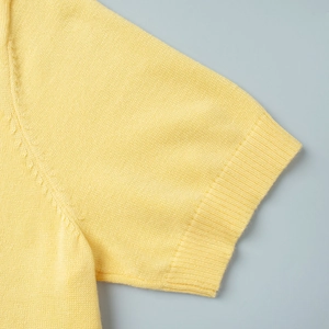 Detail of a bright yellow knit short sleeve top showing fine ribbed texture and soft fabric