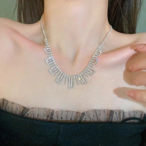 Close-up of sparkling rhinestone tassel necklace worn on model's neckline