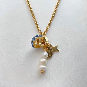 Detailed view of stainless steel necklace pendants with pearls and blue rhinestones.