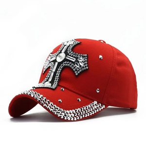 Macro detail of red rhinestone baseball cap featuring a sparkling crystal cross design