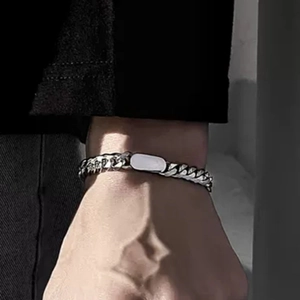 Silver Cuban link bracelet with rectangular metal plate shown on a person's wrist