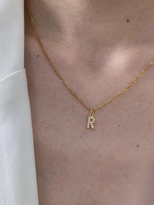 Detailed close-up of a gold-plated letter R pendant necklace with micro-pave zircons