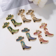 Detail view of western cowboy hat and boot earrings in emerald, gold, blue, and pink colors