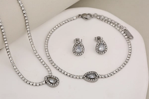 Detailed macro view of silver stainless steel jewelry set with teardrop zircons