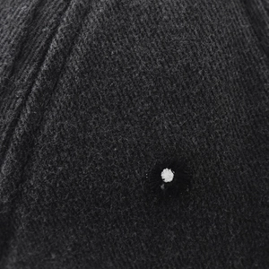 Close-up macro of washed cotton baseball cap fabric with white circular button detail