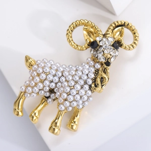 Close-up of golden sheep brooch with white pearls and sparkling crystal details