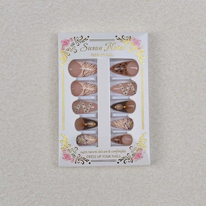 Detail of French leopard print press-on nails with 3D chain and floral pattern