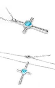 Detail of cross pendant with blue heart gemstone and white zircon stones on silver chain