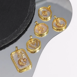 Detailed macro view of gold resin charms with sun moon and star patterns for DIY jewelry
