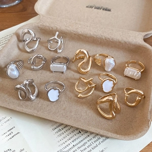 Detail of adjustable gold and silver rings with irregular pearls in vintage packaging